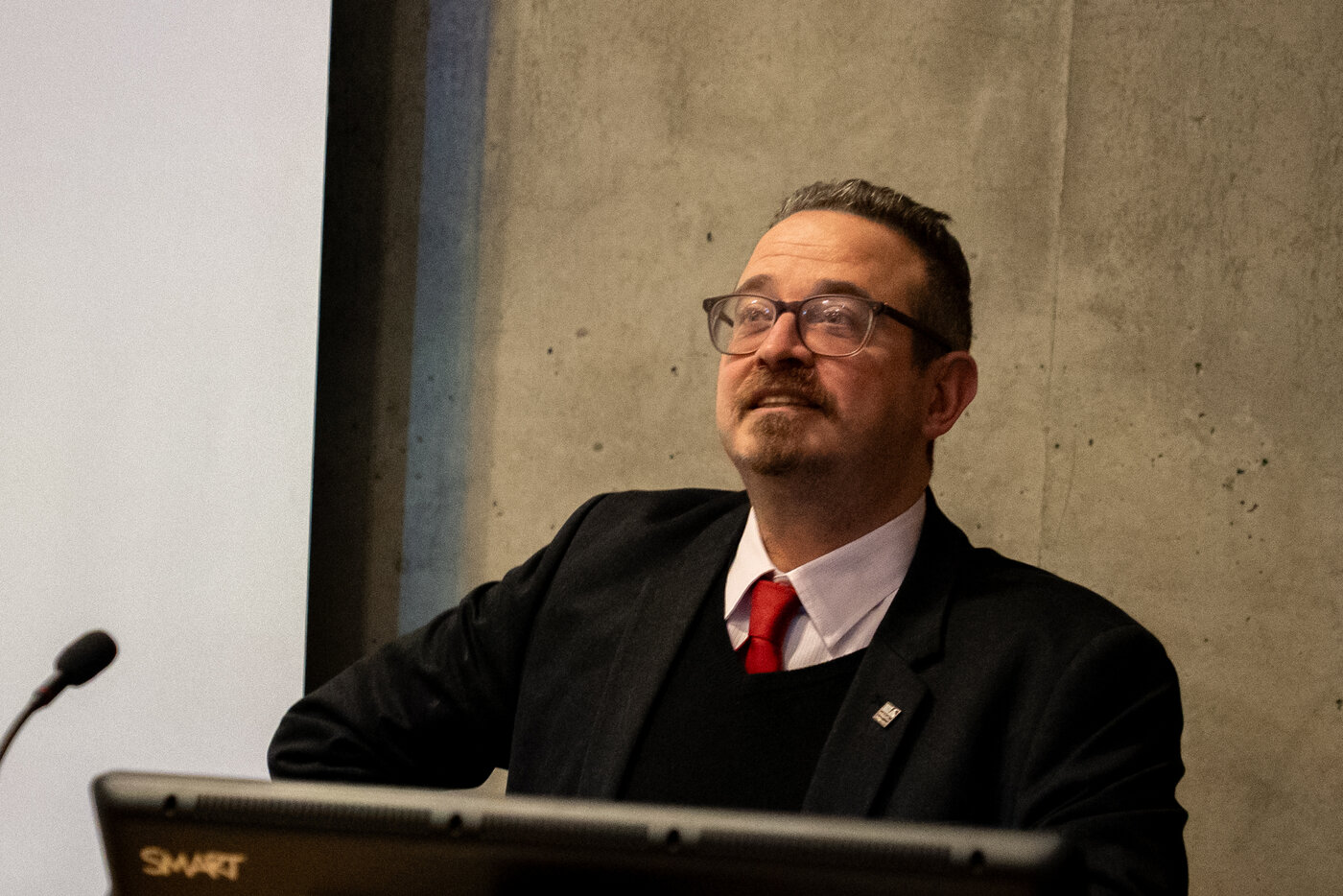 Giorgio Baruchello speaking at a lectern